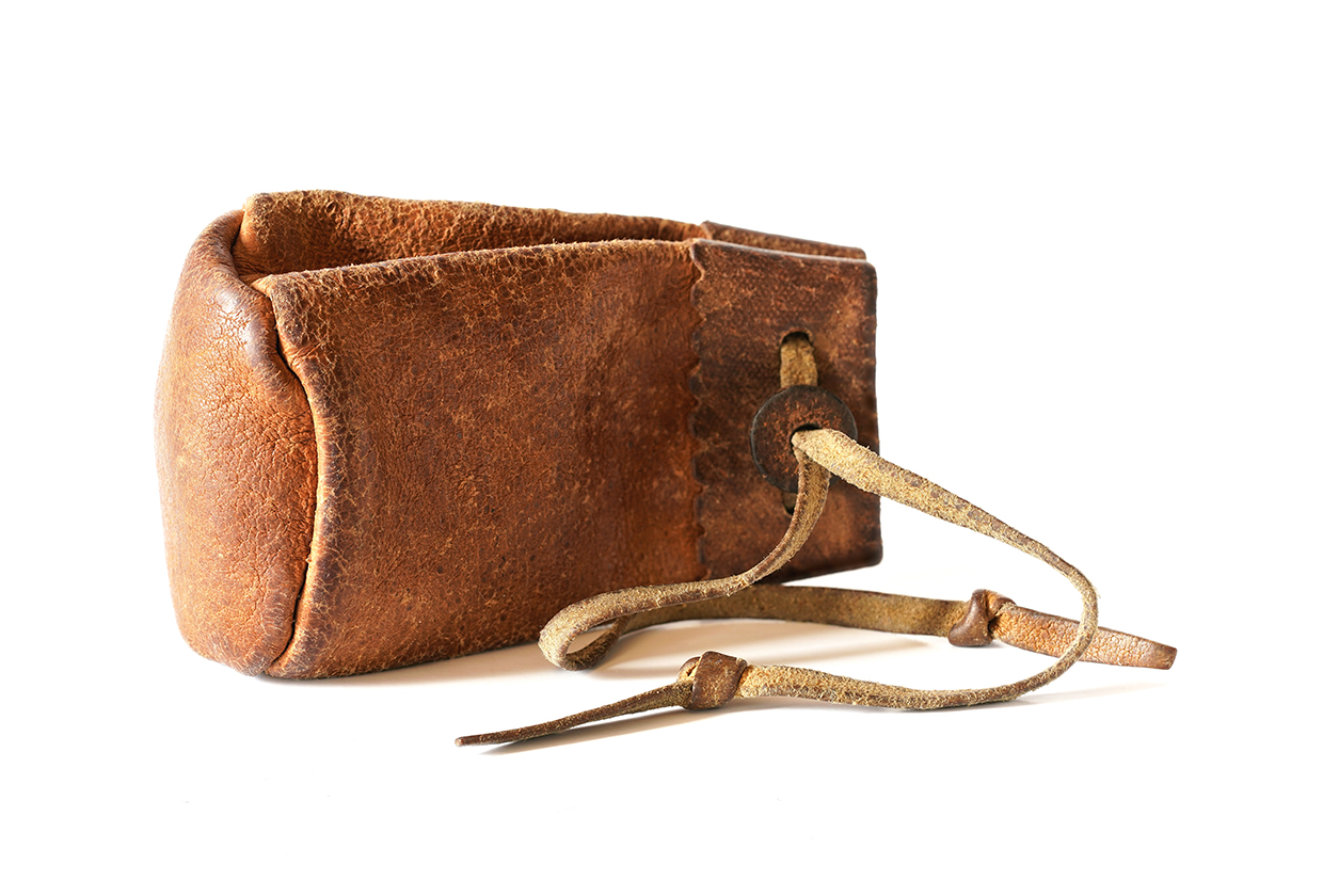 Old worn leather coin pouch isolated on white background.